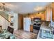 Kitchen showcasing wood cabinets, stainless appliances, and laminate floors, seamlessly connects to the dining area at 4933 Altura St, Denver, CO 80239
