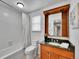 Cozy bathroom featuring tiled walls, shower-tub, wood vanity, and a decorative plant at 7426 S Hudson Way, Centennial, CO 80122