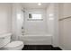 Tiled bathroom features a bathtub with gold hardware and a small window at 3350 S Eudora St, Denver, CO 80222