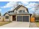 Charming two-story home with a stone and stucco exterior, gray roof, dark garage doors and driveway at 3350 S Eudora St, Denver, CO 80222