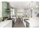 Open-concept kitchen with a green backsplash, stainless steel appliances and large island with white countertop at 3350 S Eudora St, Denver, CO 80222