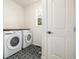 Well-lit laundry room featuring a washer and dryer with dark-tiled flooring at 3350 S Eudora St, Denver, CO 80222
