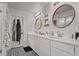 Elegant bathroom with double sinks, decorative mirrors, patterned floor tiles, and 'love you more' wall decor at 5446 Coltin Trl, Castle Rock, CO 80104