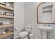 Powder room with stylish mirror, faucet, toilet, and shelving at 5446 Coltin Trl, Castle Rock, CO 80104