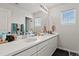 Bright bathroom featuring double sinks, a large mirror, and a window for natural light at 5446 Coltin Trl, Castle Rock, CO 80104