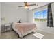 Bright bedroom with a ceiling fan, large window overlooking a scenic view, and cozy throw blanket at 5446 Coltin Trl, Castle Rock, CO 80104
