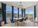 Bright dining room features a wood table, blue chairs, large windows, and stylish light fixture at 5446 Coltin Trl, Castle Rock, CO 80104