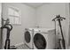 Well-lit laundry room featuring modern washer and dryer units and patterned tile flooring at 5446 Coltin Trl, Castle Rock, CO 80104