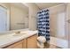 Bathroom featuring a single sink vanity and a shower-tub combination with a patterned curtain at 9617 Bighorn Way, Littleton, CO 80125