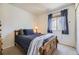 Bedroom with a wood-framed bed, dark blue bedding, and a window with dark blue curtains at 9617 Bighorn Way, Littleton, CO 80125