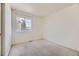 A minimalist bedroom with neutral walls, carpet flooring, and a window providing natural light at 9617 Bighorn Way, Littleton, CO 80125