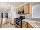 A view of the kitchen, with stainless steel appliances, light wooden cabinets, and sight lines to the living room at 9617 Bighorn Way, Littleton, CO 80125