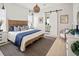 Coastal bedroom with a textured headboard, striped rug, and sliding barn door to the bathroom at 888 S Valentia St # 103, Denver, CO 80247