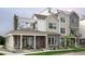 Attractive modern townhome showcasing a mix of brick and siding, complemented by a covered porch and second-story deck at 888 S Valentia St # 103, Denver, CO 80247