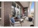 Comfortable front porch seating area with wicker chairs, decorative pillows, and a view of the neighborhood at 888 S Valentia St # 103, Denver, CO 80247