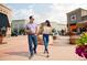 Residents walking around at shopping center with outdoor fountain and landscaped planters at 888 S Valentia St # 103, Denver, CO 80247