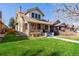 Well-maintained home featuring a covered front porch and lush green lawn at 4415 N Clay St, Denver, CO 80211