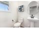 Charming powder room with modern pedestal sink and creative toilet paper holder at 4104 N Picadilly Ct, Aurora, CO 80019