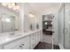 Well-lit bathroom featuring double sinks, a walk-in shower, and a bedroom view at 4104 N Picadilly Ct, Aurora, CO 80019