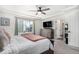 Well-lit bedroom with a ceiling fan, king-size bed, and a dresser with a television at 4104 N Picadilly Ct, Aurora, CO 80019