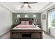 Bright bedroom with an accent wall, a ceiling fan, and a king bed with a decorative spread at 4104 N Picadilly Ct, Aurora, CO 80019