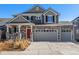 Charming two-story home with stone accents, grey siding, and an inviting front porch at 4104 N Picadilly Ct, Aurora, CO 80019