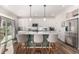 Modern kitchen with a central island, stainless steel appliances, and stylish pendant lighting at 4104 N Picadilly Ct, Aurora, CO 80019