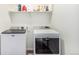 Laundry room with modern washer and dryer set, plus convenient shelving at 4104 N Picadilly Ct, Aurora, CO 80019