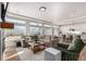 Open-concept living room with a fireplace and large windows connecting to the modern kitchen at 4104 N Picadilly Ct, Aurora, CO 80019