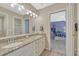 Bathroom with granite countertops, double vanity, large mirror, and view into bedroom at 7672 S Ensenada Ct, Centennial, CO 80016