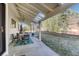 Relaxing covered patio with a table setting, chandelier, and a serene view of the lush green surroundings at 7672 S Ensenada Ct, Centennial, CO 80016