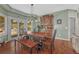 Inviting dining room featuring a rustic wood table, built-in cabinet, and access to the outdoors at 7672 S Ensenada Ct, Centennial, CO 80016