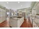 Open kitchen design with an island cooktop, hardwood floors, and seamless flow into the dining area at 7672 S Ensenada Ct, Centennial, CO 80016