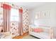 Adorable Bedroom with patterned wallpaper, a crib, soft lighting, and a playful, inviting ambiance at 6567 S Elizabeth Way, Centennial, CO 80121