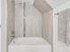 Bathroom featuring a soaking tub with light neutral tiling and a glass accent stripe at 3333 Osage St, Denver, CO 80211