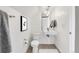 Modern half-bathroom with a floating sink, unique mirror, and white fixtures at 3333 Osage St, Denver, CO 80211