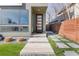 Contemporary home entrance with manicured lawn, modern pathway and striking glass-paneled front door at 3333 Osage St, Denver, CO 80211