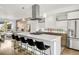 Modern kitchen with stainless steel appliances, island with seating and gas cooktop, and white cabinetry at 3333 Osage St, Denver, CO 80211