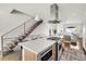 Kitchen island with seating, gas cooktop, and double ovens, open to living spaces and staircase at 3333 Osage St, Denver, CO 80211