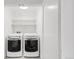 Bright laundry room equipped with a modern washer and dryer, complemented by practical shelving at 3333 Osage St, Denver, CO 80211