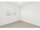 Bright bedroom featuring neutral carpet, large windows, and fresh, white walls at 1826 Hickory Ave, Erie, CO 80516