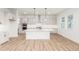 Open kitchen featuring an island, white cabinetry, stainless steel appliances, and plenty of natural light at 1826 Hickory Ave, Erie, CO 80516