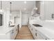 Contemporary kitchen featuring an island with a sink, white cabinets, stainless appliances, and wood floors at 1826 Hickory Ave, Erie, CO 80516