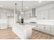 Elegant kitchen with white cabinets, stainless steel appliances, a center island, and hardwood flooring at 1826 Hickory Ave, Erie, CO 80516