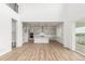 Open-concept living area with a view of the kitchen, light wood floors, and a modern interior design at 1826 Hickory Ave, Erie, CO 80516