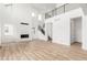 Open-concept living room with high ceilings, a fireplace, and light wood flooring at 1826 Hickory Ave, Erie, CO 80516