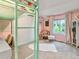 Stylish bedroom boasts a colorful loft bed, chair, and bright pink walls, creating a fun and inviting retreat at 208 N Foote Ave, Lafayette, CO 80026