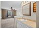 Bathroom with a sink vanity with a framed mirror and carpeted bedroom in background at 8900 Iris Ct, Broomfield, CO 80021