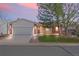 Charming single-Gathering home featuring a manicured front lawn, brick accents, and an attached two-car garage at 8900 Iris Ct, Broomfield, CO 80021