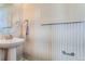 Elegant powder room with patterned wallpaper and a pedestal sink at 14099 Deertrack Ln, Parker, CO 80134